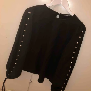  - En jättefin svart blus med fina pärlor på ärmarna.   Aldrig använd!  Nypris - 149  Säljer den för 100kr + frakt  Storlek M (passar även S) 