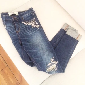  - Tighta jeans från hollister. I gott skick! Brodyr och små strasstenar på.