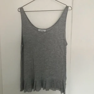  - grått linne med volang längst ner som är köpt på JC. funkar som en M/L i storlek. skönt och bekvämt tyg. köparen står för frakten.