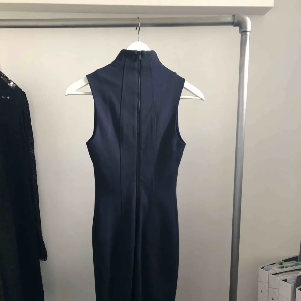 Mörkblå figursydd klänning från Calvin Klein med låg polokrage. Svart dragkedja i ryggen som går hela vägen ner, kan dra upp nedre dragkedjan för att kunna röra sig bättre. Använd 2 ggr passar xs-s. Klänningar.