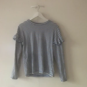  - Blå/vit randig tröja med volanger.