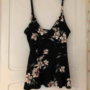  - Sött peplum linne från Gina Tricot. Aldrig använt. Fina blomdetaljer, rätt urringat. Checka gärna in min profil för mer!! Frakt tillkommer.