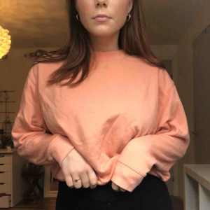  - weekday croppad sweatshirt i peachig färg!! liten fläck på som inte gått bort i tvätten!! passar xs - m