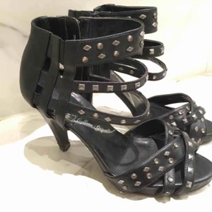  - Sexiga svarta pumps med nitar och stenar strl 39. Använda några ggr och har lite slitna klackar, se bild, men är annars i fint skick! 