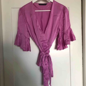  - Lila omlottopp med volanger med knytband i midjan från Zara, glansigt sidenmaterial.  Lite skrynklig då bilden.  Använd en gång. Kan mötas upp eller frakt för 30kr😊