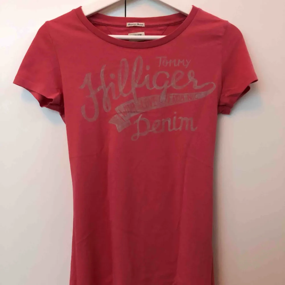 Säljer denna Tommy Hilfiger T-shirt i storlek XS. Färgen är något av en smutsrosa. Knappt använd.. T-shirts.