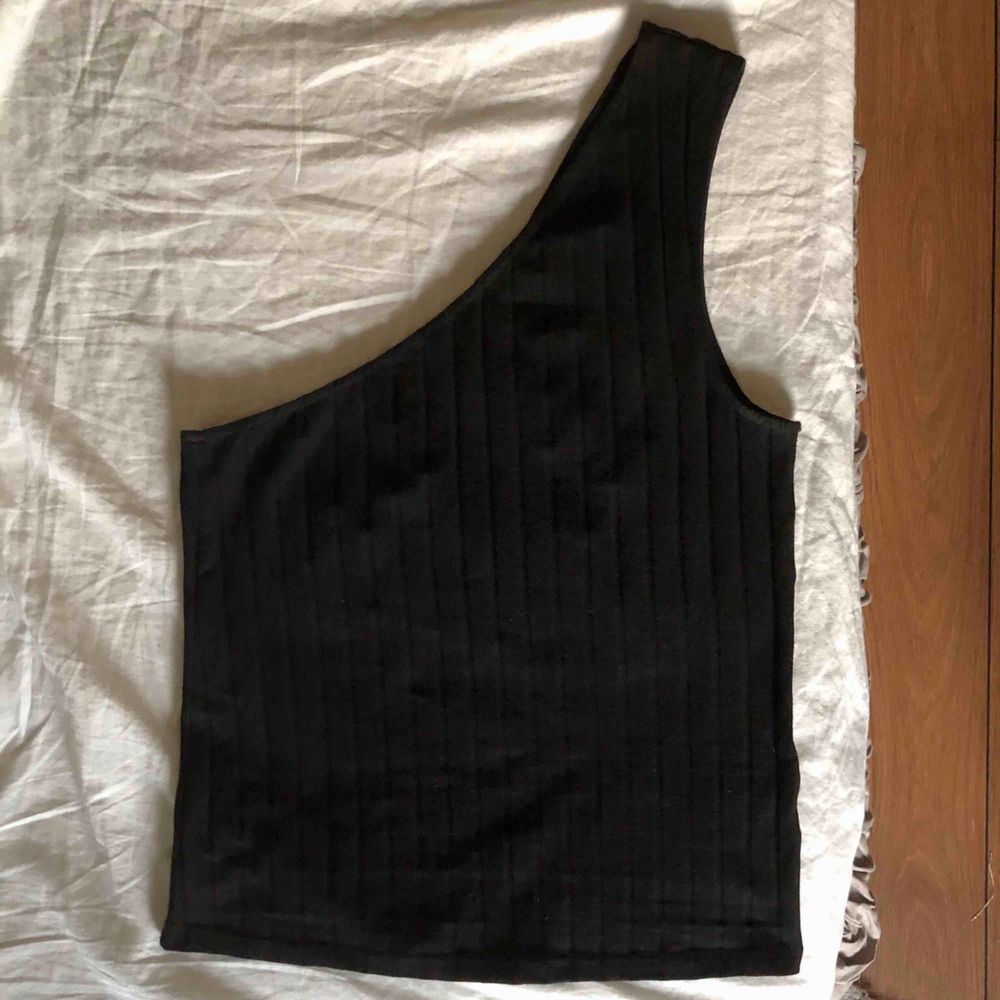 Ribbat svart one-shoulder linne från en kollektion på nakd.köpt i höstas och använt vid ett tillfälle bara, alltså så gott som ny! Tunt o skönt materialet.. Toppar.