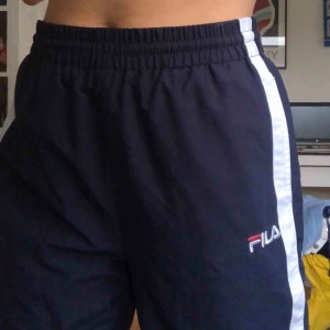  - Mina älskade Fila-byxor, köpta på Urban Outfitters! Marinblå med vita stripes och rosa kant! Skönt material!! Frakt tillkommer.