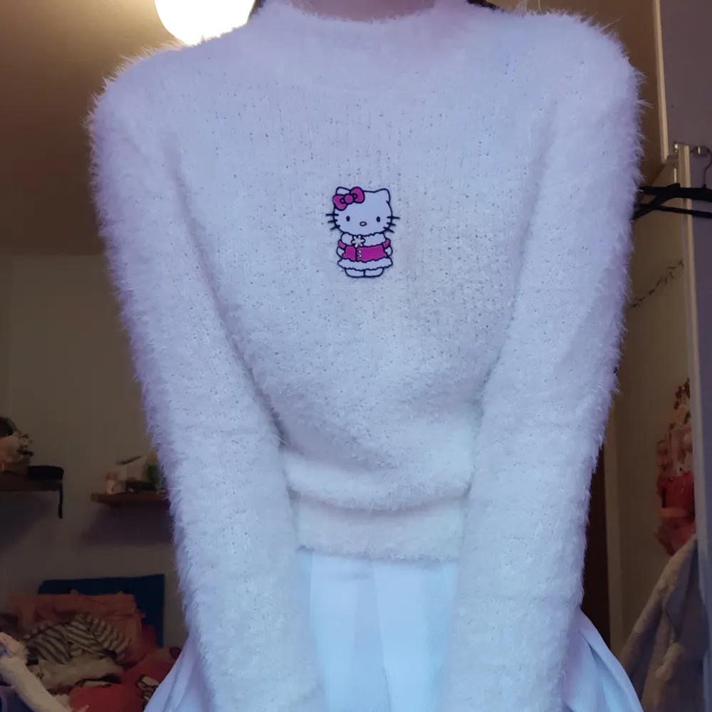 Vit fluffig tröja med en patch mitt på av Hello Kitty i vinterjacka. Den har lite missfärgning på ena sidan av hello kitty från att stryckjärnet var lite för varmt. Det är inte jättetydligt men det syns lite på bild 2. Budgivning, DM/kommentera! Högsta bud: 350 (exkl frakt). Stickat.