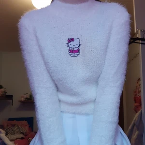 Fluffig Hello Kitty tröja - Vit fluffig tröja med en patch mitt på av Hello Kitty i vinterjacka. Den har lite missfärgning på ena sidan av hello kitty från att stryckjärnet var lite för varmt. Det är inte jättetydligt men det syns lite på bild 2. Budgivning, DM/kommentera! Högsta bud: 350 (exkl frakt)