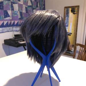 En kort grå-blå peruk i bra kvalite. Just nu är den stylad i stil med karaktären Ciel från Black Butler. 