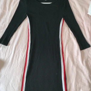 Svart fin klänning från Gina! - Svart fin klänning får Gina med röd vita detaljer längs midjan!