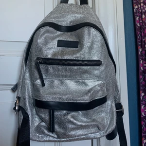 Silvrig ryggsäck - En fet glittersilvrig rycksäck! Används inte längre men är udda och riktigt cool att ha på sig! frakt ingår inte och skriv till mig för annat prisförslag📦💓🥰 