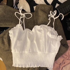 Vitt gulligt linne - Ett gulligt vitt linne med söta rosetter, säljer pga för stor, skulle säga att den passar M och uppåt bättre❤️ endast provad med prislapp kvar. du står för frakten