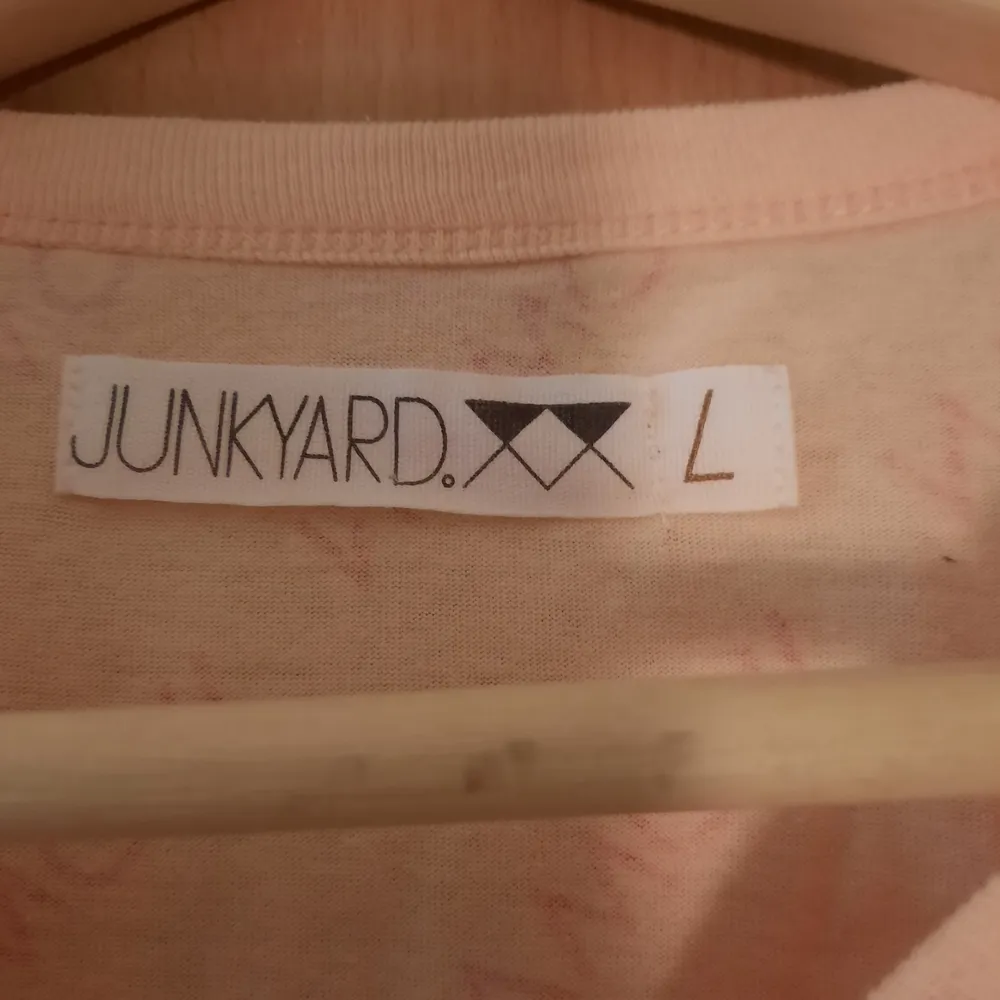Cropped T-shirt från Junkyard i strl L. Ljustosa tröja med mörkare rosa text. Köpt begagnad men jag har själv aldrig använt.Kan mötas upp eller skicka, jag står INTE för frakten. T-shirts.