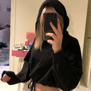 Svart kroppad hoodie, st S  - Svart hoodie som har ett band runt midjan som man knyter så att hoodien blir mer ”kroppad”. Säljer den eftersom jag inte använder den. De är en bra passform, är i storleken S men passar även som xs. 