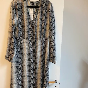 Snake klänning - Snygg klänning som inte kommit till användning då jag har en likadan i annan färg! Den är lite figursydd. Frakt tillkommer