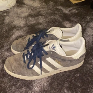 Adidas sneakers - Säljer ett par blåa Adidas Gazelle sneakers i storlek UK 7. Köparen står för frakt eller så kan vi mötas upp. Priset kan diskuteras.