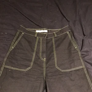 Svarta byxor junkyard - Fina svarta byxor med gröna sömmar. De sitter åt vid överdelen, blir vida i slutet. Använda fåtal gånger.