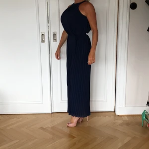 Marinblå festklänning  - Pliserad halterneck klänning modellen är 164