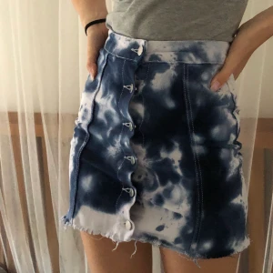 Tie dye kjol - Batikmönstrad button up kjol i vitt och blått, går att knäppa upp helt. Den sitter väldigt snyggt, passar mig som har xs-s. Kan mötas i Stockholm annars betalar köpare frakt. 