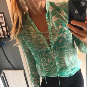 Blus - Skir blus med snörning framtill. Från H&M. Mönstrad grön/vit. Sparsamt använd. Köparen betalar eventuell frakt.
