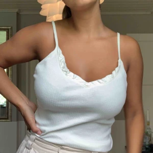  - Ribbat linne i krämvit färg. Har volang rem framtid och tunna straps. Jättefint skick, frakten står köparen för🌟🌟