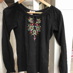  - Vacker svart blus med trendiga blommor i fina färger!🌞