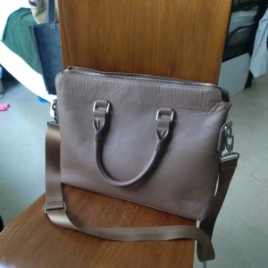  - använd några gånger bara som rekvisita, så det är inga fel på den, är bara inte i behov av den längre :) köpt på Åhléns, doftar fortfarande nyöppnad, har många små innerfack. blixtlås och avtagbar axelrem.  finns i Hammarby sjöstad.