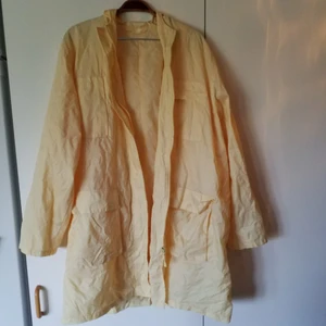  - Tunn regnjacka i ljus gul färg, står ingen storlek i den men passar de flesta storlekar beroende på hur man vill ha den