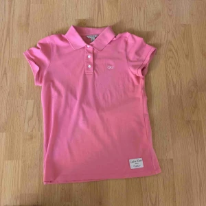  - En rosa jättefin Calvin Klein jeans piké, ej använd, sälj pga att den inte används. 100 kr, kan mötas upp i Växjö annars tillkommer frakt