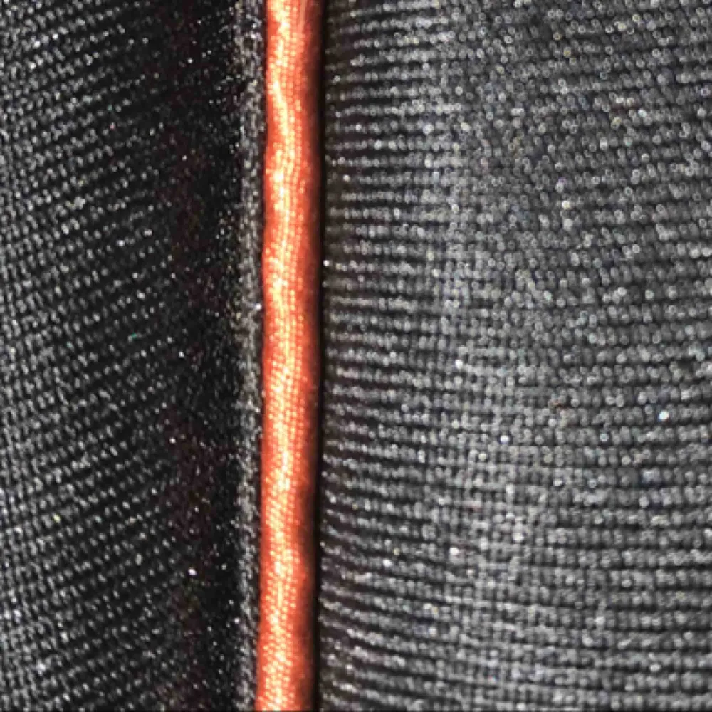 Ett svart schabrak med orange detaljer, den rutiga delen är mörk mörk brun. Använd upp till 3 ggr. Nypris 500kr mitt pris 200kr. Övrigt.