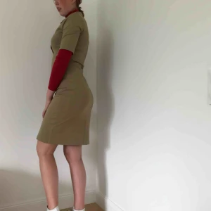  - Beige klänning från Filippa K. Sparsamt använd. Pris kan diskuteras. OBS, den röda polotröjan ingår ej i köpet, finns att köpa längre ner i shoppen.