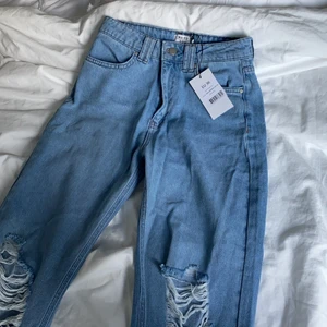 Blåa jeans med hål - Blåa jeans från nakd i storlek 36💕superskönt material och perfekt modell . Jeansen är oanvända och jag säljer dom enbart då de inte kommit till användning💕 frakt ingår i priset. Jeansen är eftertraktade och är slutsålda på nakd, nypris var 499 kr