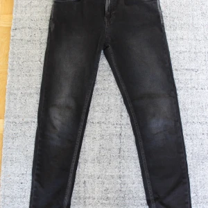 Nudie Jenas - Hightop Tilde Jeans - W31 L28 - Nyskick! - Märke: Nudie Jeans, Typ: Hightop Tilde Jeans. Storlek: W31 L28. Färg: Concrete Black, Svart/gråa. Skick: Nyskick, använda en gång. Nypris: 1199 kr.  Info: Mitt hem är rent, rök- och djurfritt. Alla bud är bindande. Jag skickar mina paket med vadderade kuvert eller inlindade i bubbelplast, för en säkert transport. Samfraktar självklart, så kolla gärna in mina andra annonser.