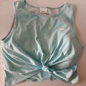  - Turkos cropad linne från Stronger. Går att knyta samt knyta upp. Passar både S-L. Ordinariepris 299 kr