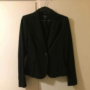  - Väldigt fin figursydd svart kavaj. Två knappar att knäppa framtill. Se knappar nedre del av ärmen. Säljes pga platsbrist i garderoben...:-)