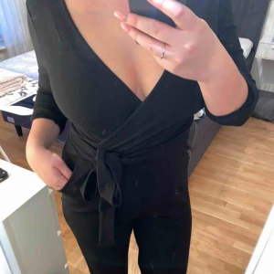  - En snygg och enkel ”Wrap Jumpsuit” i skönt och stretchigt material. Med knyte i midjan och vidare ben. Kommer tyvärr aldrig till användning, använd 1 gång! Köparen står för frakten. 