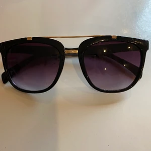 Solglasögon  - Solbrillor, svarta som fedas lila med gulddetaljer. 