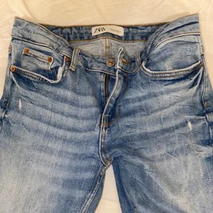 Zara utsvänga jeans - Ett par ljus blåa jeans från Zara, de är även utsvängda och slitna där nere. De är köpte exakt som på bilden, ifall ni tånker att det är jag som slitit på jeansen. Lågmidjade. 