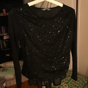 Svart glittertopp - Svart glittertopp från Lindex i barnstorlek 158/164. Passar perfekt till fest. Knappt använd. Frakt tillkommer.