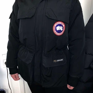 Canada Goose parka i gott skick - Jackan är av äkta märke, priset är lågt då jag inte använder den och vill ha sålt den. Letar du just nu efter en varm och skön, men ändå stilren jacka till vintern? Då har du hittat rätt! Jackan är endast använd ett fåtal gånger, så den är så gott som ny! Det är en dunjacka, så den håller värmen väldigt bra. Den har en innerficka och 9 ytterfickor varav en sitter på höger ärm. Den har även midjeband, så att den håller passformen bra! Storleken är XXS i herrmodell, men jag passar i den och brukar ha M i jackor (jag är kvinna). Tar emot swish!