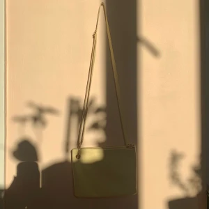 Gul axelremsväska  - Liten citrongul väska från monki. Har två fack och är jättegullig! Använd en gång men har fläckar från tuschpenna på ett ställe på remmen. 