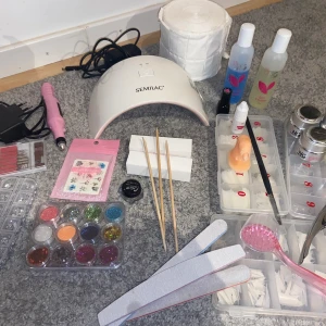 Gelenaglarkit - Säljer mina nagelsaker för jag tappat intresset 1 Elfil med tillbehör 1 Semilac uvlampa samt semilac gelefärg i neon rosa 3 Filar 2 Buffers 3 Nagelbands pushers 1 Nagelbandsolja 12 Oanvända glitter, 1 använd glitter 1 Nagelborste 1 Uvgel borste 1 Nageltång/klippare 3 Pack med tippar varav en helt oanvänd, resten är använd väldigt fåtal gånger 1 Träningsfinger 1 Lim 3 Nageltatueringar 1 Clean off solution ungefär 60ml 1 Nail Cleaner ungefär 75ml 1 Nagelpadsrulle 1 Topgel 30g knappt använd 1 Primergel 15g 1 White gel 15g