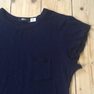  - Jättesöt mörkblå klänning från Urban Outfitters i bra skick. Endast använd 3 gånger! Skatemodell med liten ficka på bröstet, superskönt material! 🌺 Köparen betalar frakt eller möts upp i Stockholm🌺