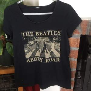  Svart Beatles t-shirt med djup ringning. 