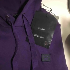  - Superfin lila acne studios hoodie. Har bara använt den en gång, dock har den ett litet hål vid sömmen som jag inte vet vad det är från men det syns knappt (visas bild 2). Nypris: 2300kr. Kan mötas upp i Sthlm! Pris går att diskutera. Passar XXS-S