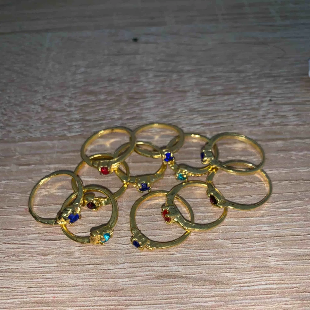 Säljer 10 st fina guldfärgade ringar för 100kr  Olika färger på stenarna. 15kr/st. Och du köper fler än 5st får du dem för 10kr/st. . Accessoarer.