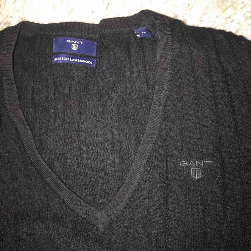 En svart kabelstickad tröja från Gant med v-ringning. Väldigt bra skick. 85% lambwool, 15% nylon. Storlek: M (dam) Nypris: 1299kr. Tröjor & Koftor.