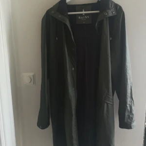  - Knappt använd regnjacka från Rains. Militärgrön färg Storlek S/M